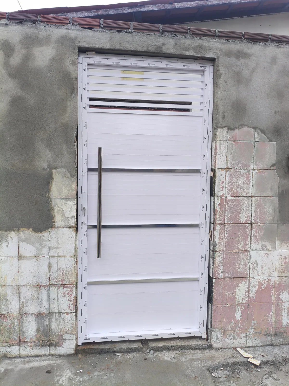 Porta de alumínio branco com palhetas superiores e puxador vertical